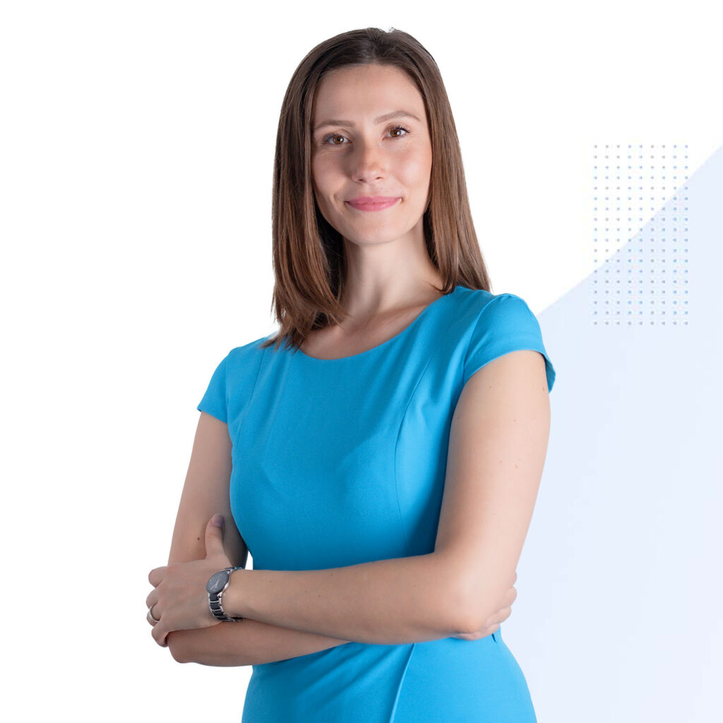 O femeie într-o rochie albastră care pozează pentru o fotografie.