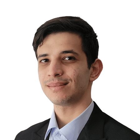 Un tânăr cu păr scurt și închis, purtând o jachetă de costum și cămașă albastră deschisă, zâmbește ușor pe un fundal alb simplu, întruchipând o imagine profesională, dar accesibilă, ideală pentru orice echipă SEO.