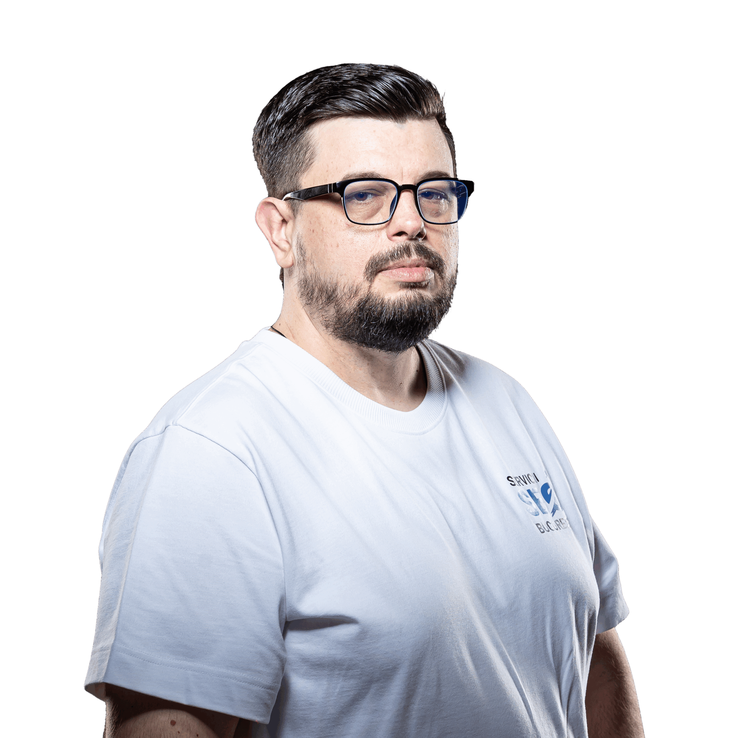 Un bărbat cu părul scurt închis la culoare, barbă și ochelari poartă un tricou alb și se uită la cameră pe un fundal alb simplu, emițând o vibrație profesională perfectă pentru fotografia de profil a unui expert SEO.