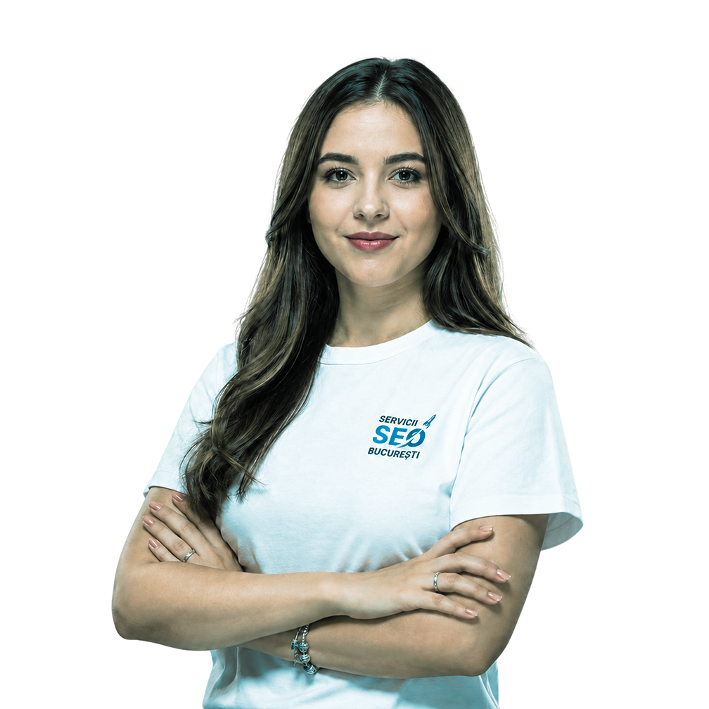 Femeie cu păr lung șaten, purtând un tricou alb pe care scrie "SEO București", stând încrezătoare cu brațele încrucișate, gata să își împărtășească expertiza SEO pe un fundal deschis.